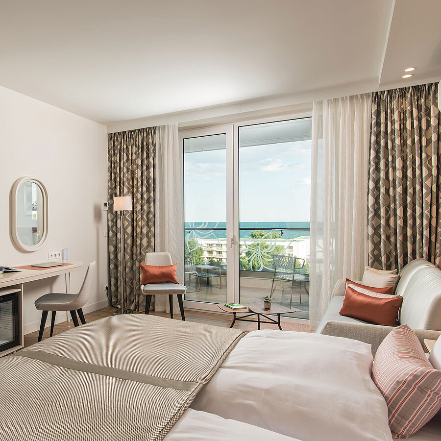 Helles Zimmer im Maritim Hotel Amelia mit Schreibtisch, Sitzbereich und Balkonblick auf das Meer